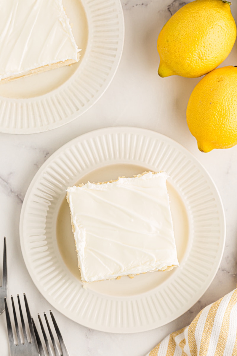 Overhead view of two pieces of lemon cake on white plates