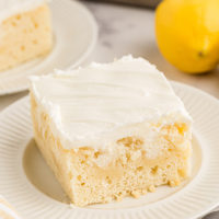Piece of lemon poke cake on white plate