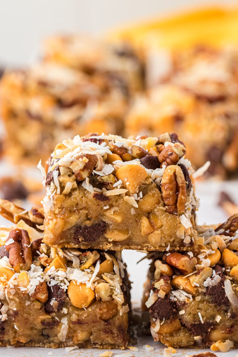 three toffee squares stacked with more bars in the background