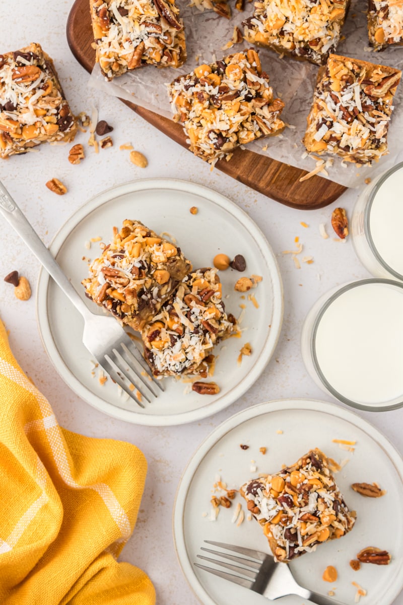 overhead view of toffee squares on white plates and a wooden cutting board