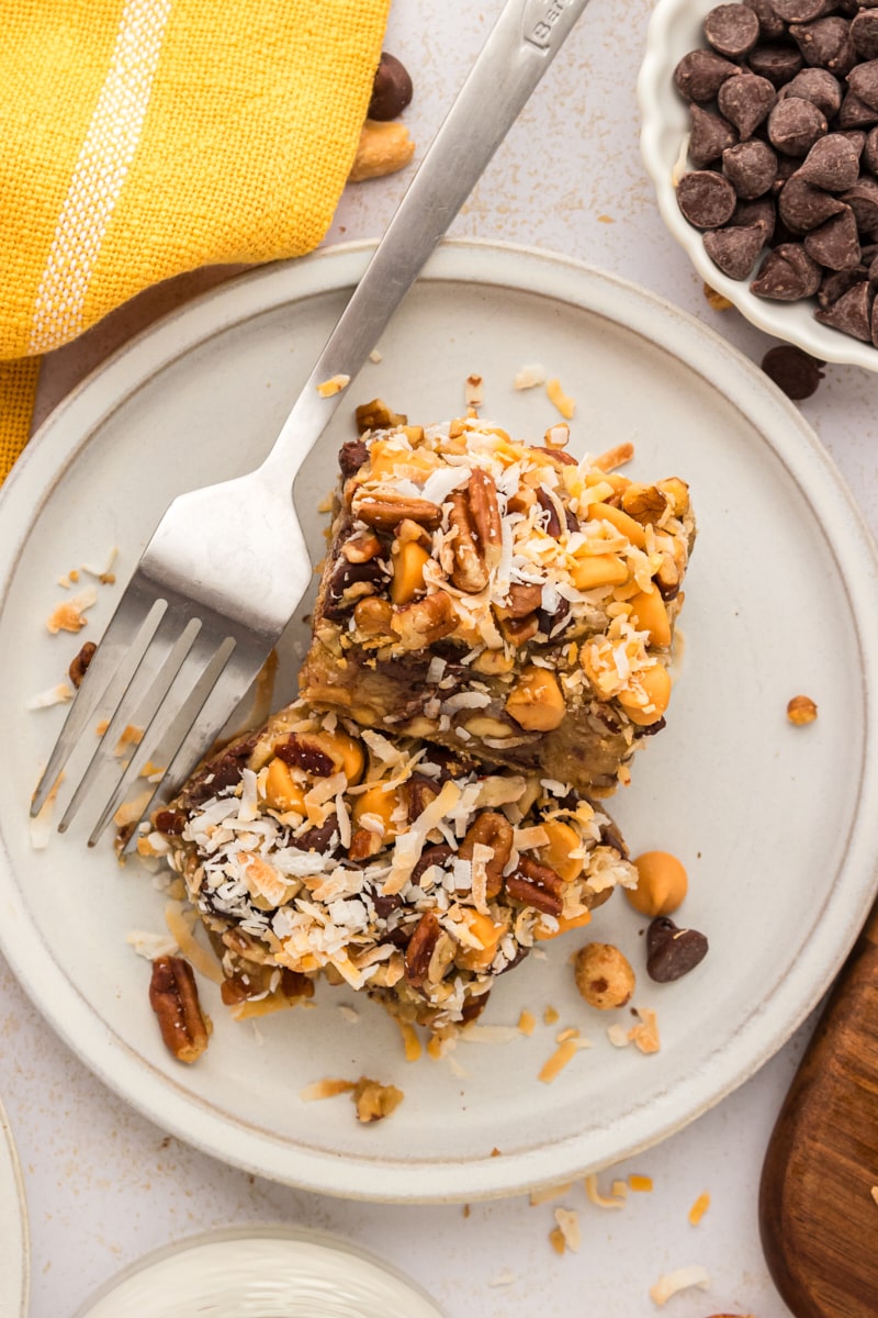 overhead view of two toffee squares on a white plate with a fork