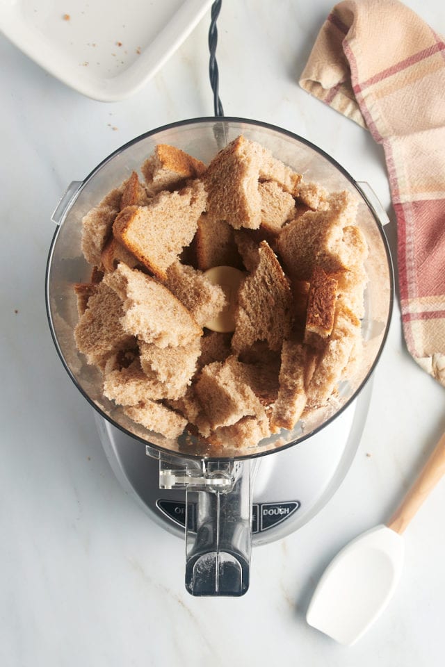 Overhead view of torn bread pieces in food processor bowl