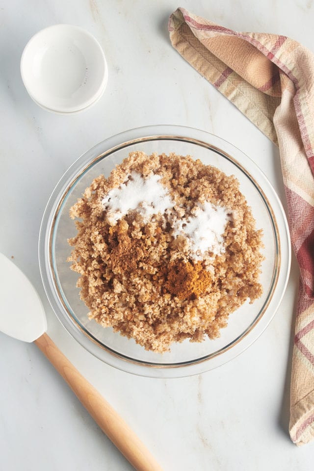 Overhead view of ingredients for breadcrumb topping in glass bowl