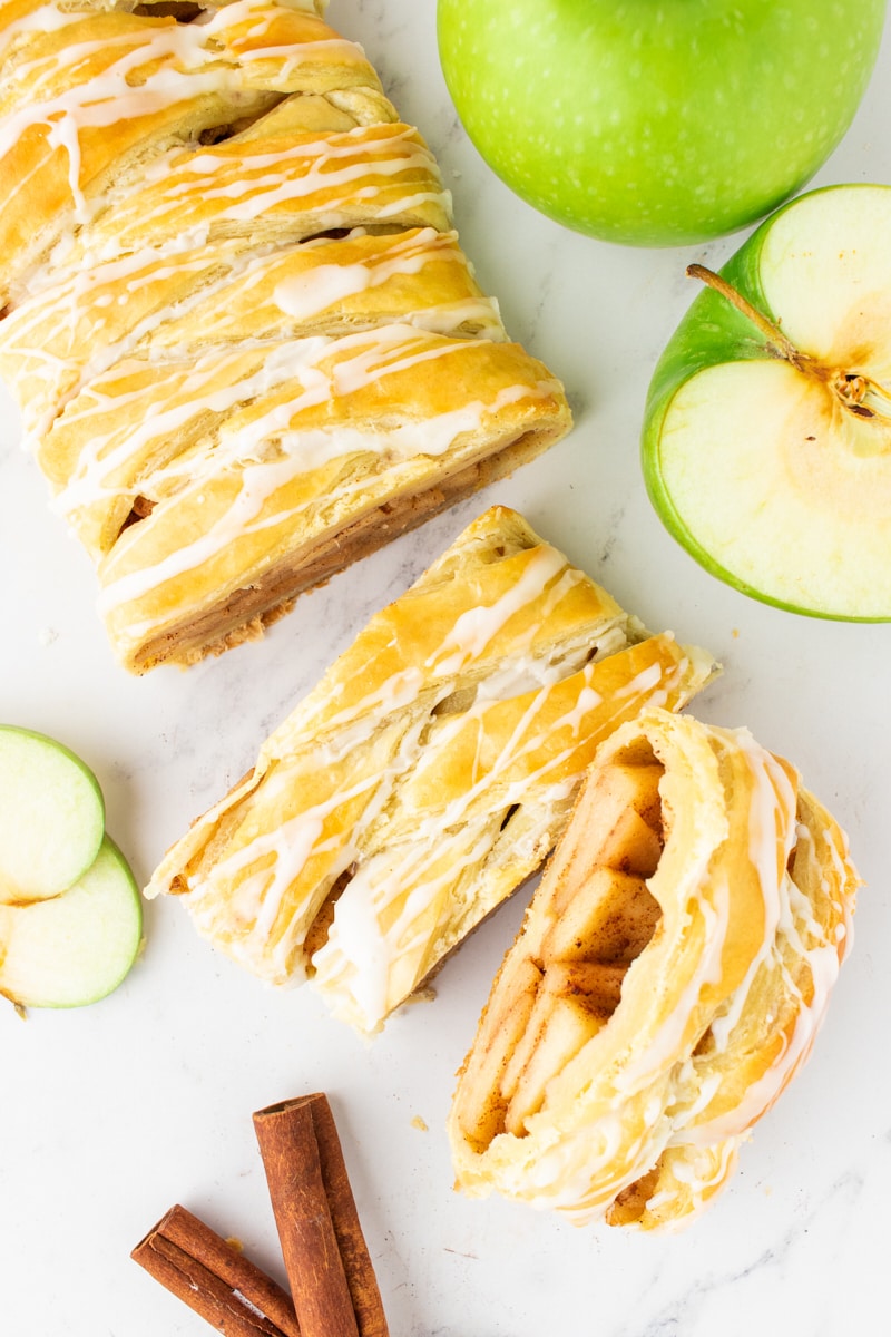 overhead view of sliced apple strudel on a marble surface