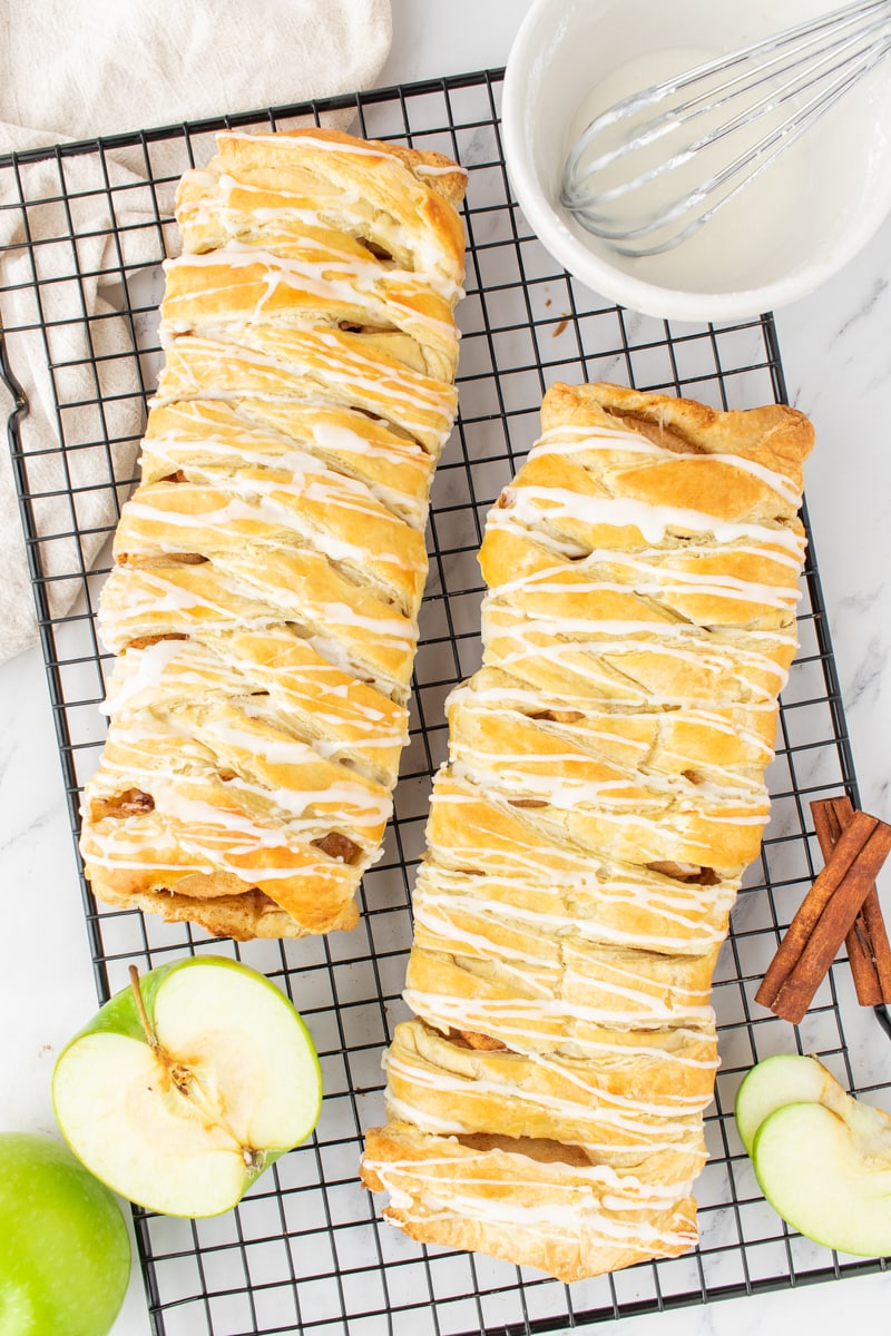overhead view of two apple strudel pastries on a wire rack