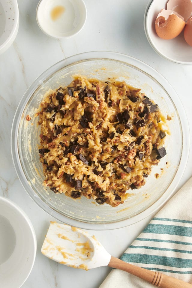 Overhead view of chocolate chunk pecan cookie dough in glass bowl