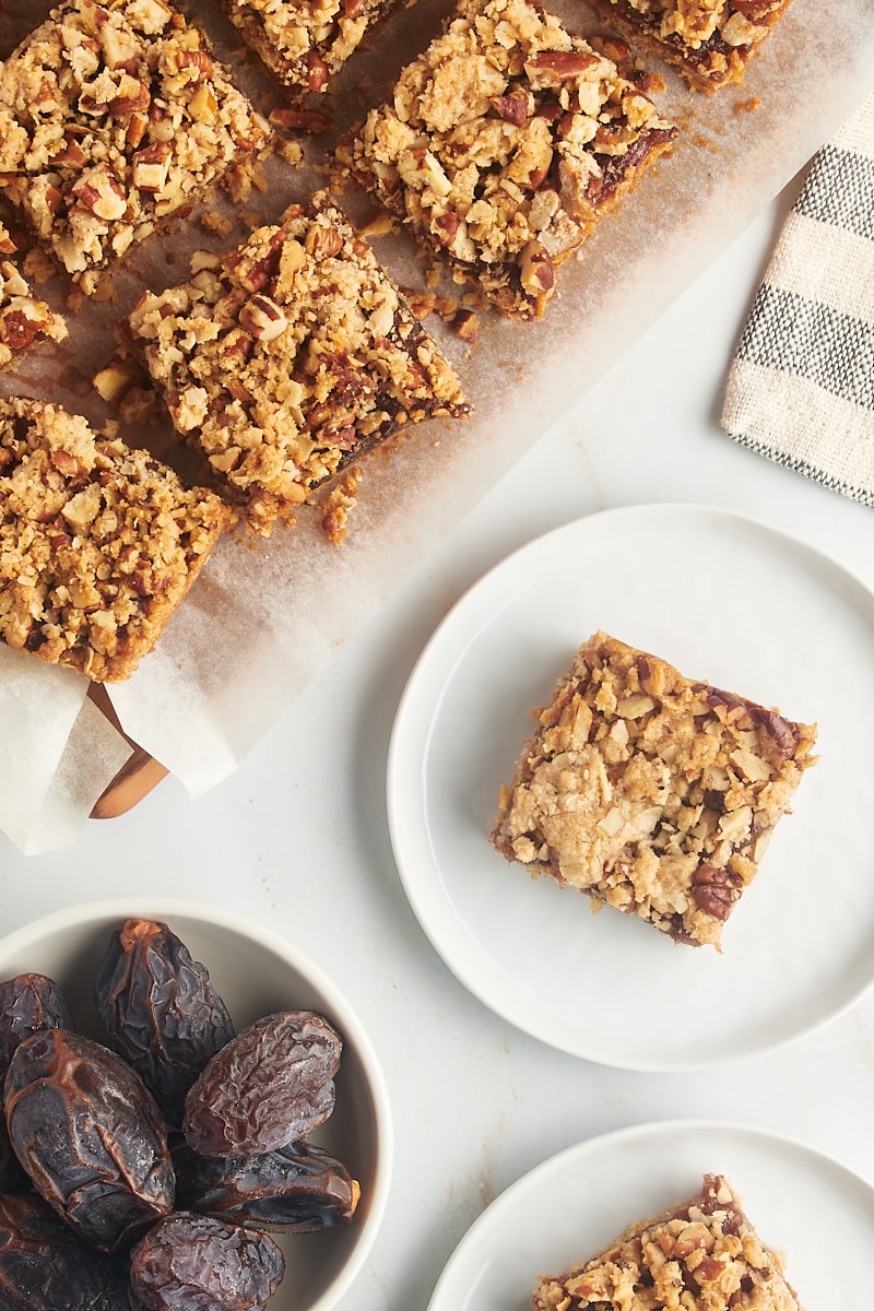 Overhead view of date bars on plates and parchment lined cutting board