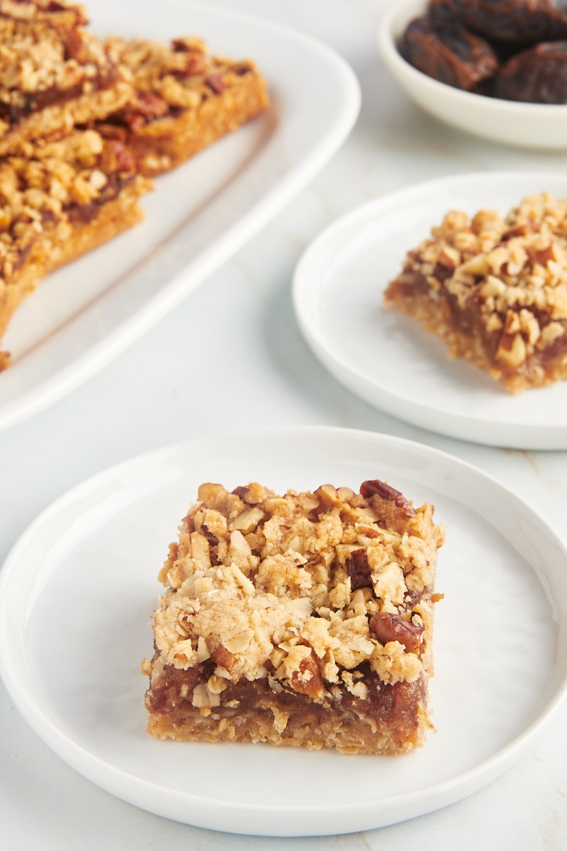 Two plates of date bars, with additional bars on platter in background