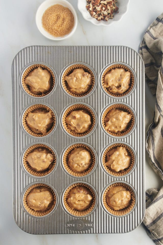 overhead view of portioned date nut muffin batter in a muffin pan