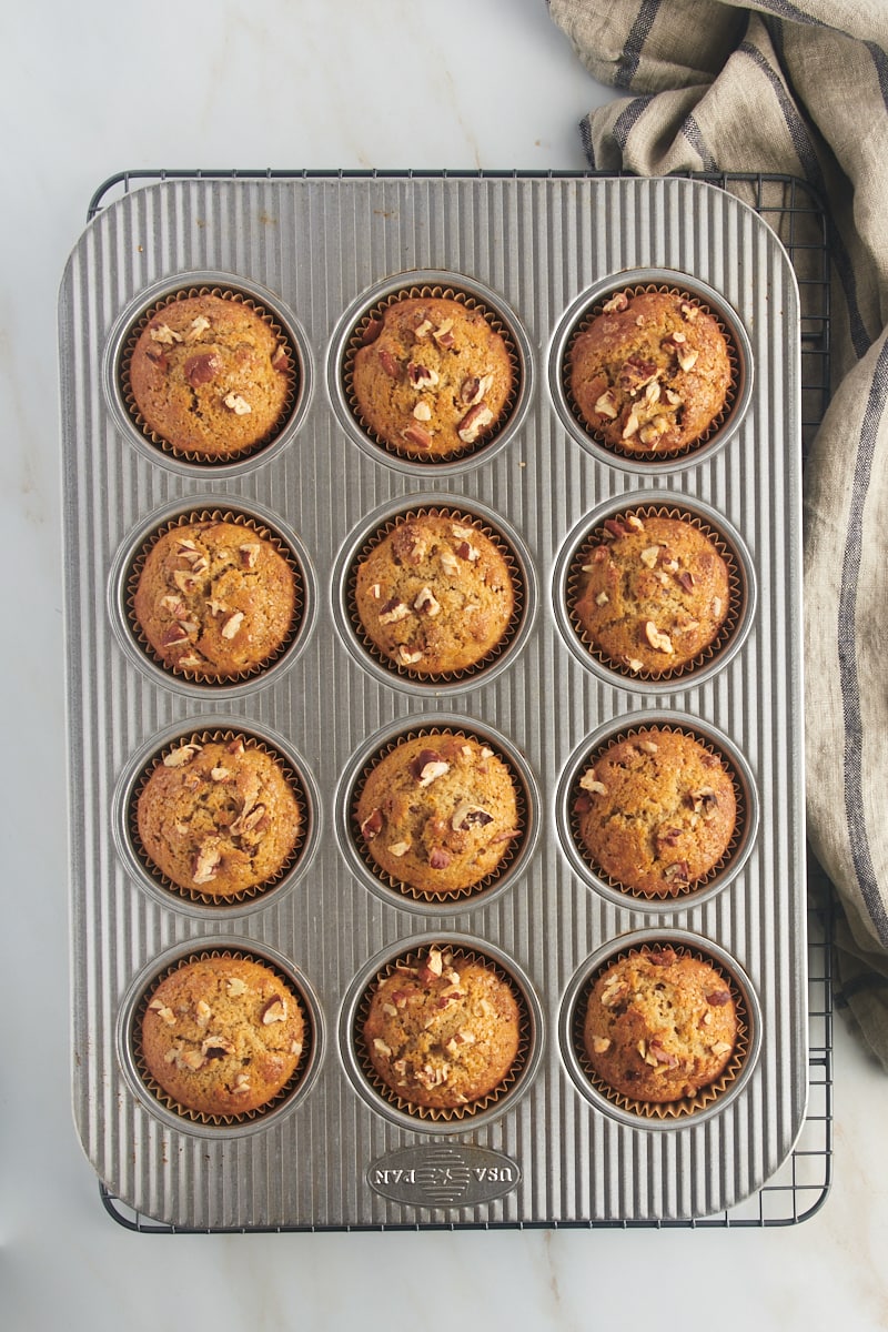 overhead view of freshly baked date nut muffins in a muffin pan