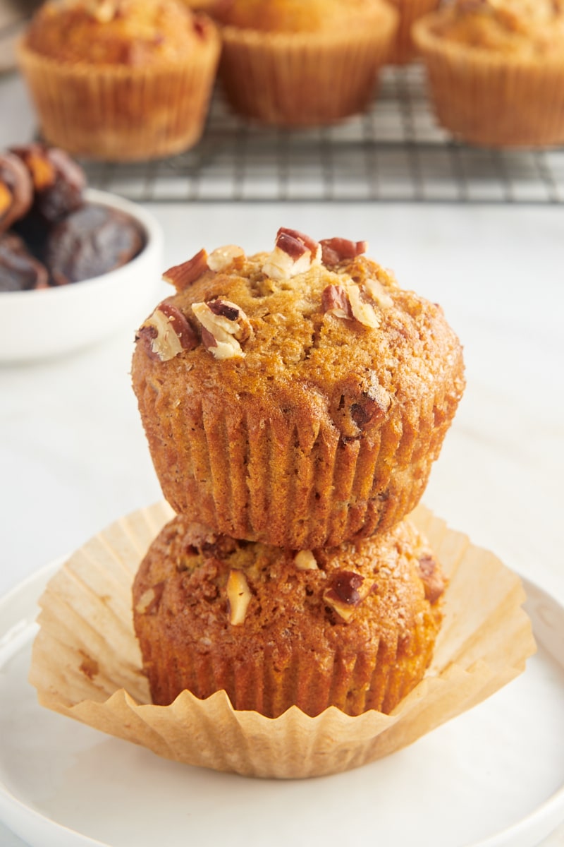 two stacked date nut muffins on a white plate