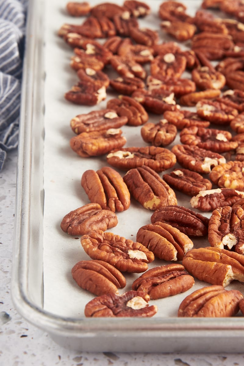 toasted pecans on a baking sheet lined with parchment paper