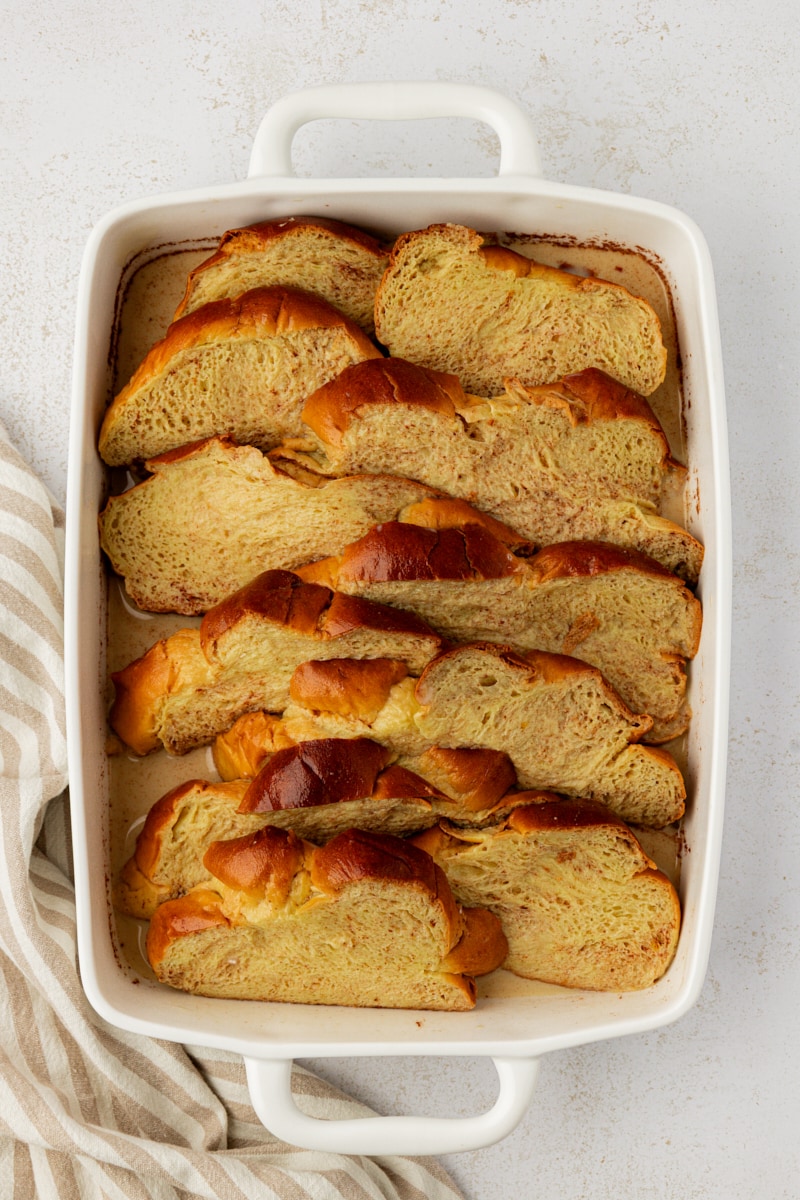 Overhead view of sliced challah in baking dish