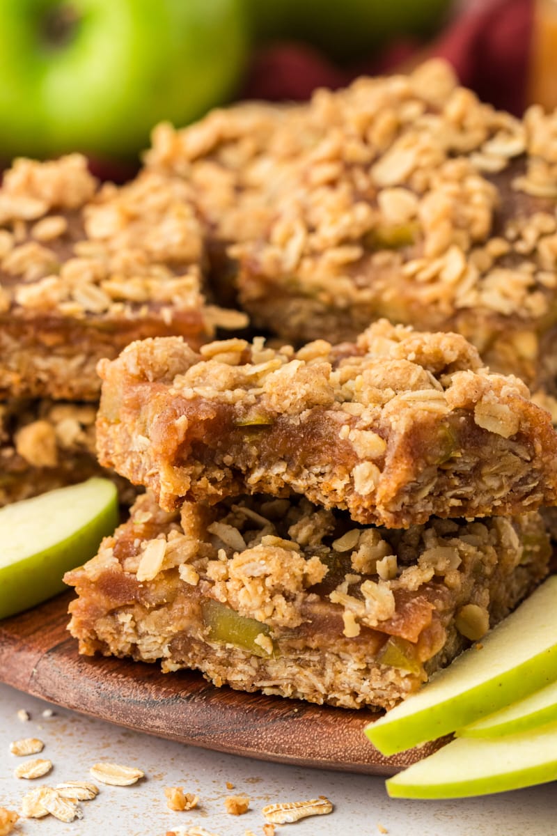 Caramel apple bars stacked on wood cutting board