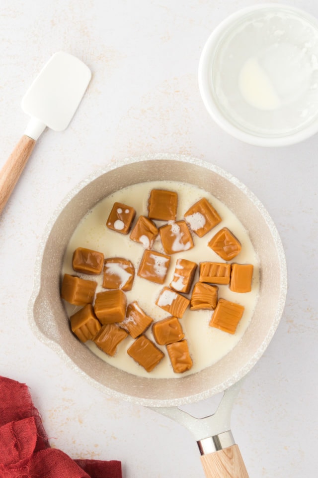 Overhead view of caramels and heavy cream in pan