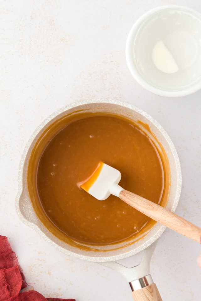 Overhead view of caramel in pan with spatula