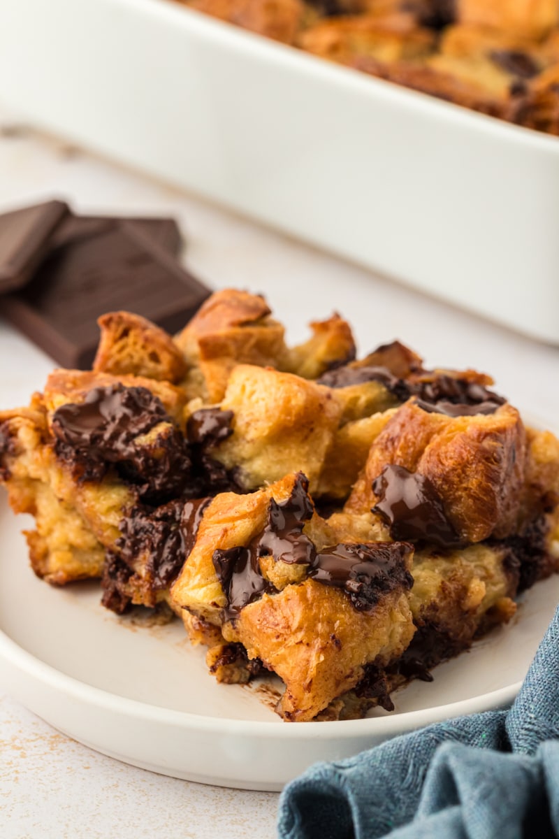 Serving of chocolate croissant bread pudding on white plate