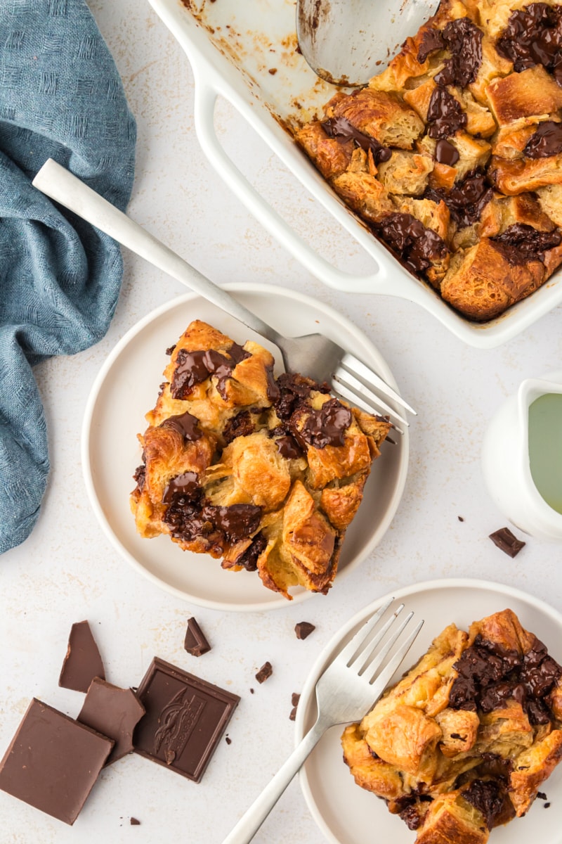 Overhead view of chocolate croissant bread pudding on plates with forks
