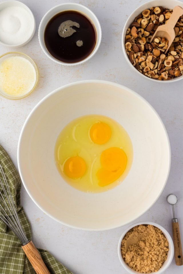 Overhead view of cracked eggs in mixing bowl