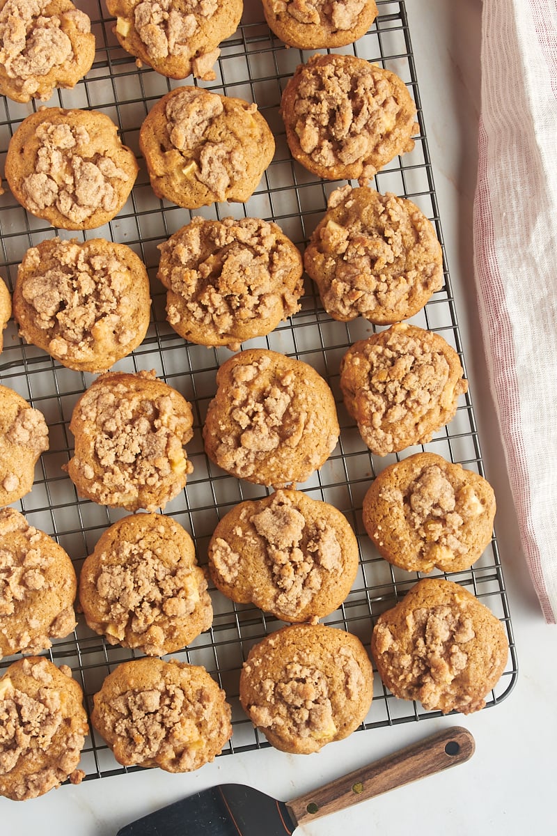 Overhead view of crumb-topped apple cookies on a wire rack.