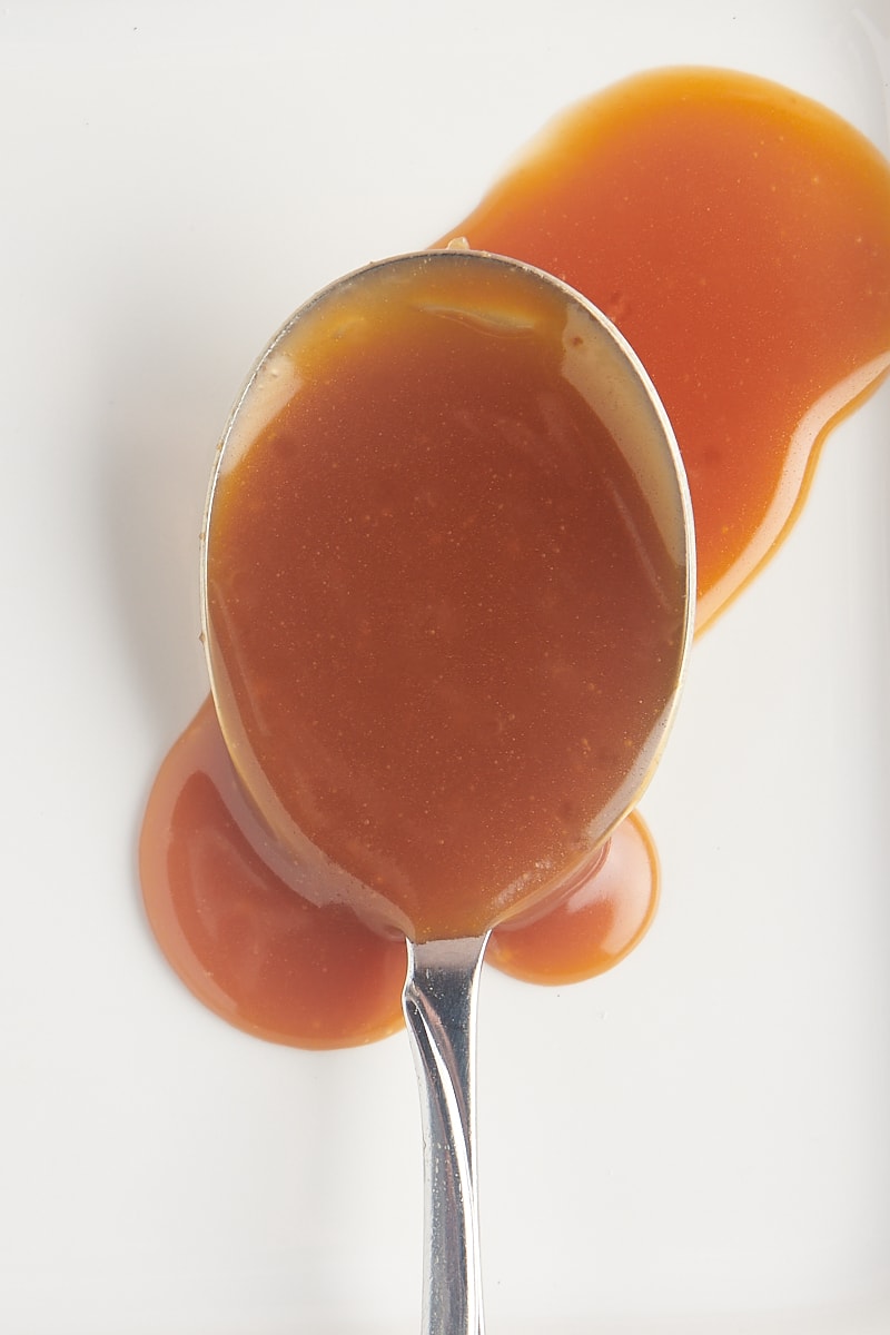 a spoonful of caramel sauce on a white plate