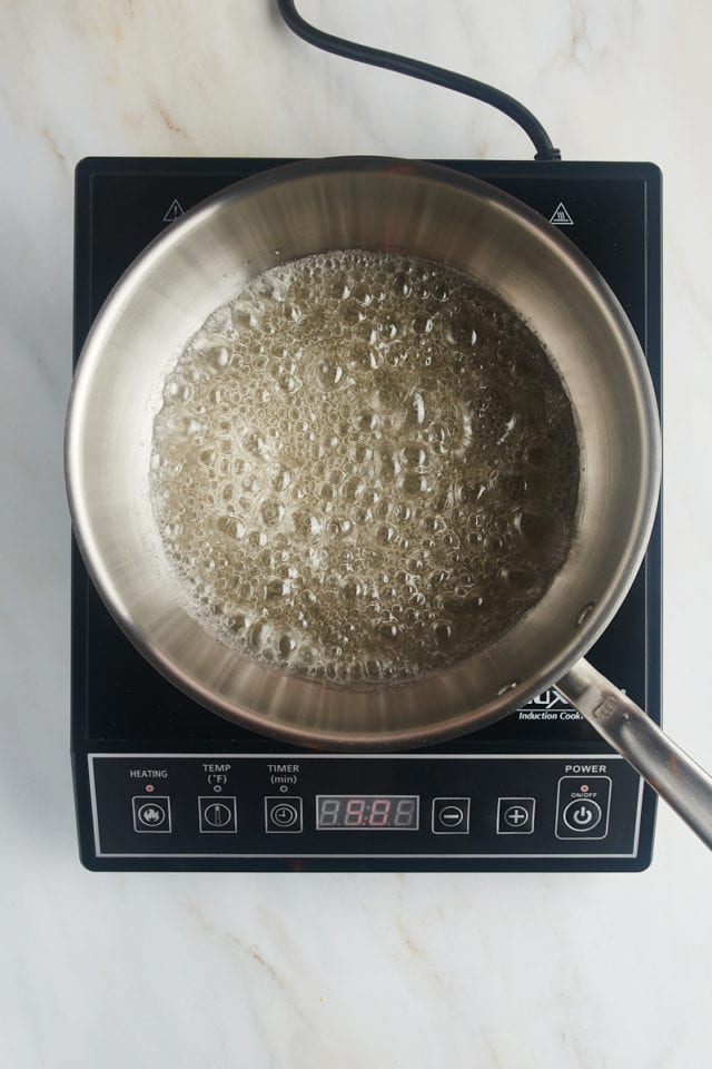 overhead view of sugar, water, and corn syrup boiling in a saucepan