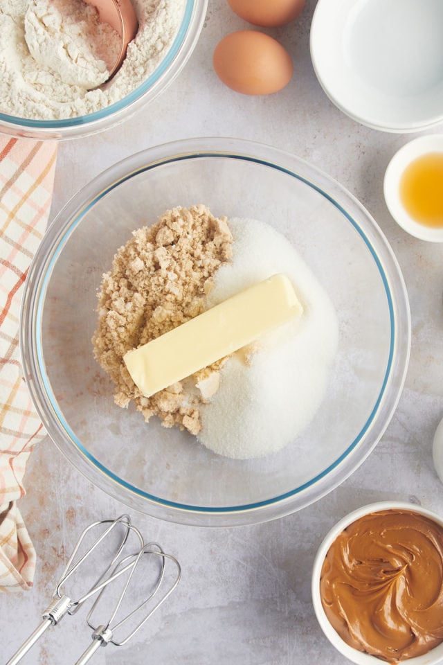 overhead view of butter, sugar, and brown sugar in a glass mixing bowl