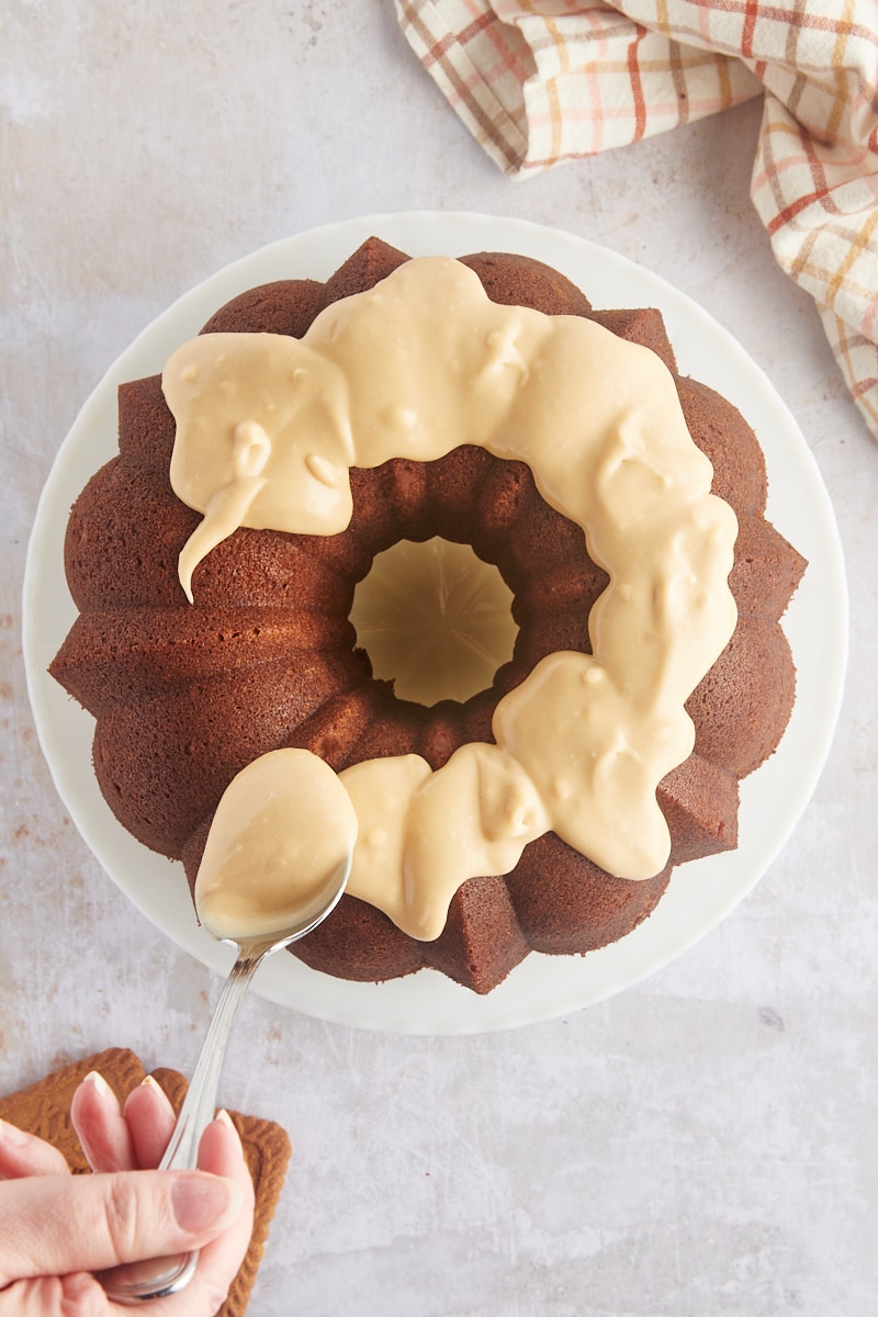 overhead view of glaze being spooned over Cookie Butter Bundt Cake