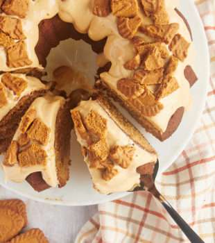 overhead view of partially sliced Cookie Butter Bundt Cake with a slice on a cake server