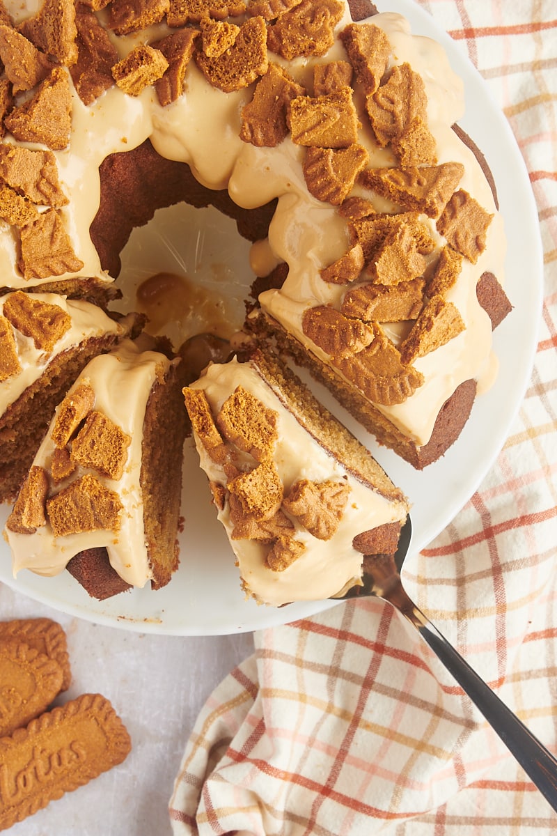 overhead view of partially sliced Cookie Butter Bundt Cake with a slice on a cake server