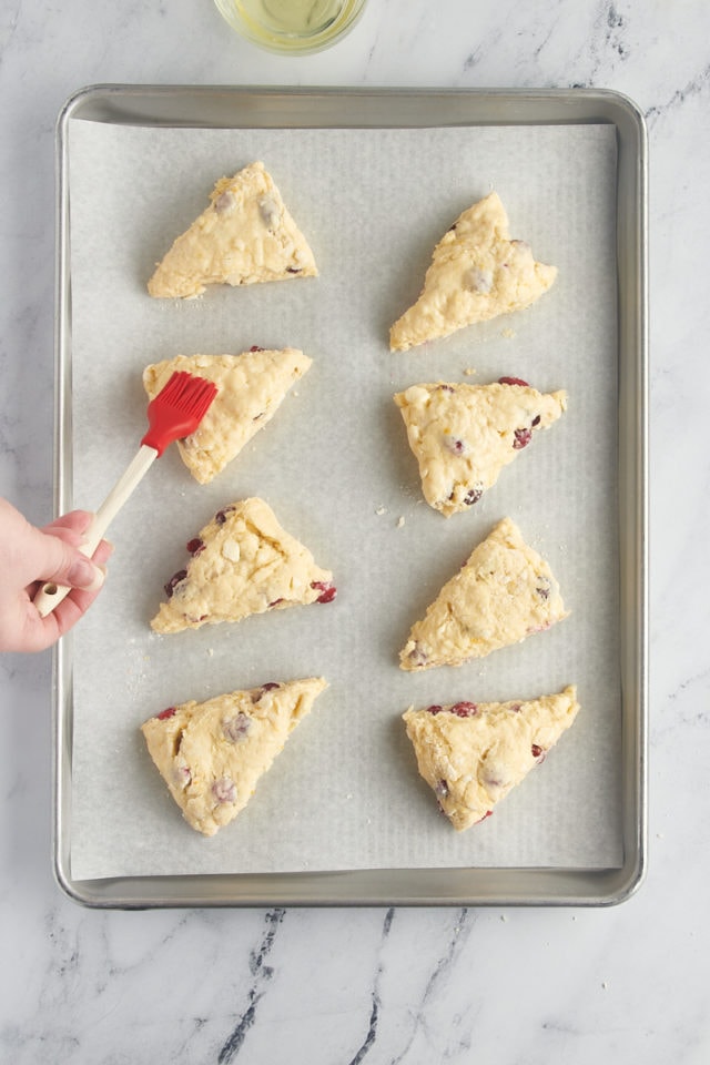 overhead view of cranberry orange scones being brushed with egg white