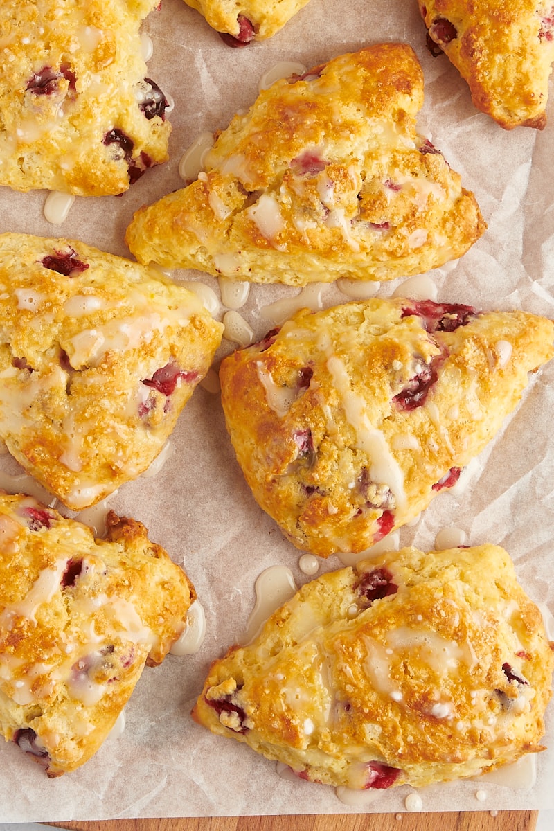 overhead view of glazed cranberry orange scones on parchment paper