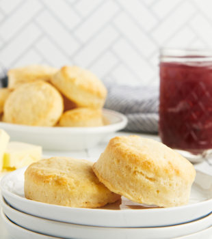 Stack of white plates with two cream biscuits on top