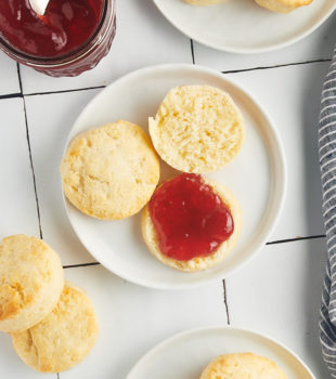 Overhead view of cream biscuits on plates with jam