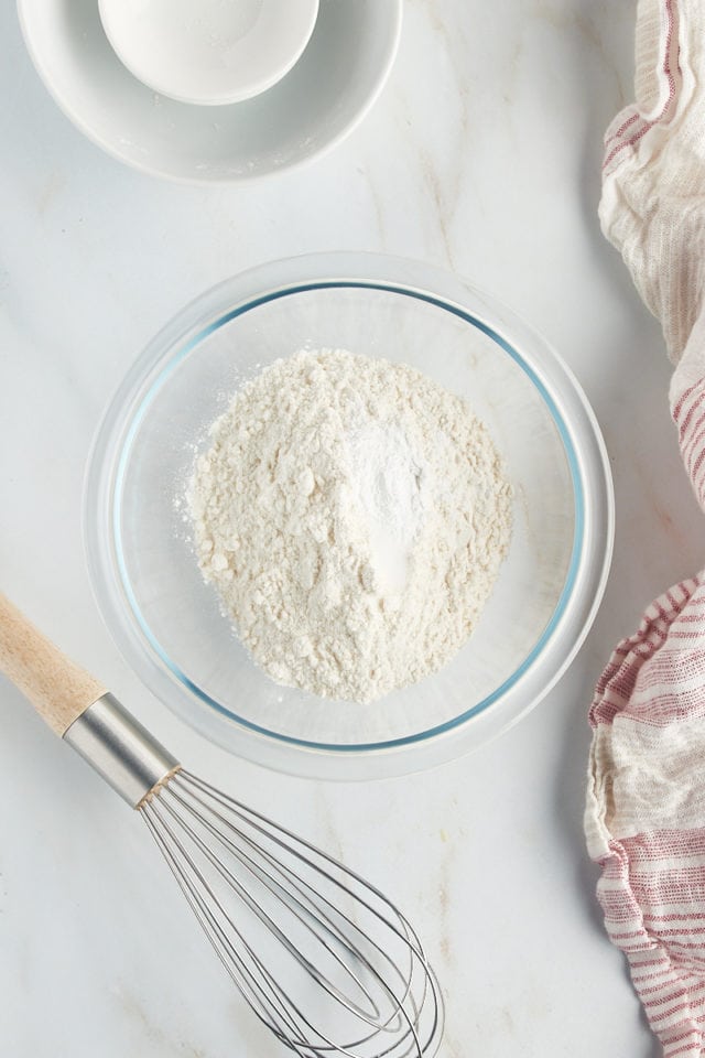overhead view of flour, baking powder, and salt in a glass mixing bowl