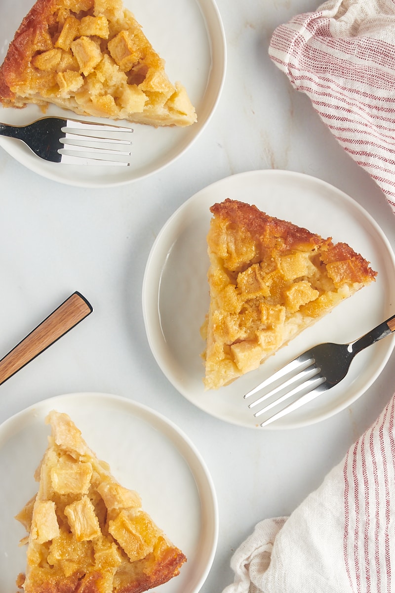 overhead view of three slices of French apple cake on white plates