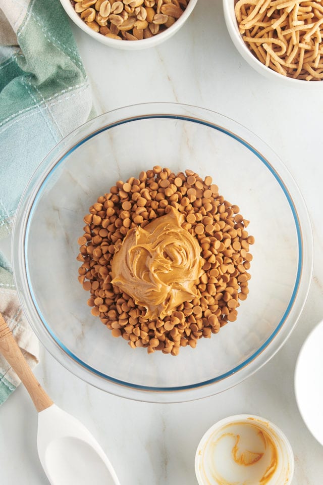 overhead view of butterscotch chips and peanut butter in a glass mixing bowl