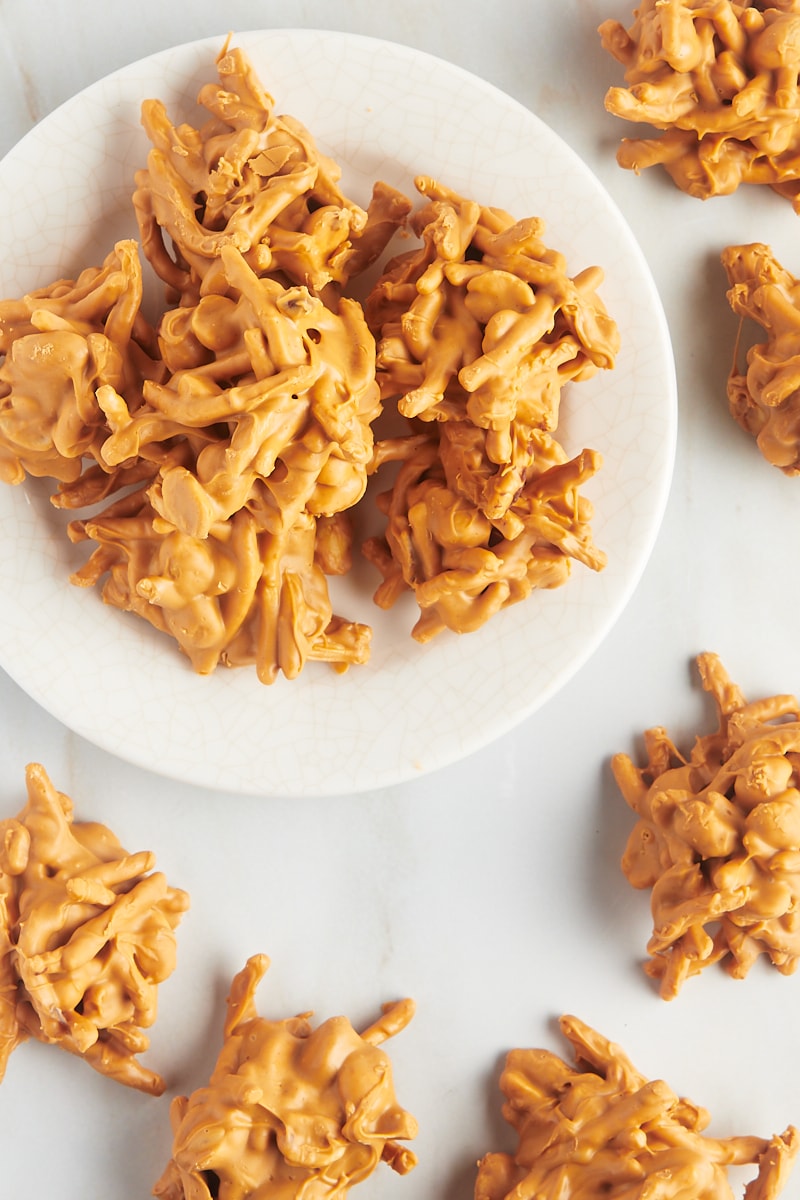 overhead view of butterscotch Haystacks on a white plate with more of the treats surrounding the plate