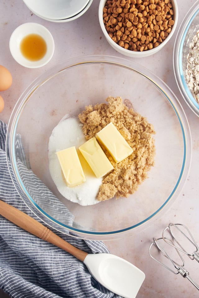 Overhead view of butter and sugars in glass bowl