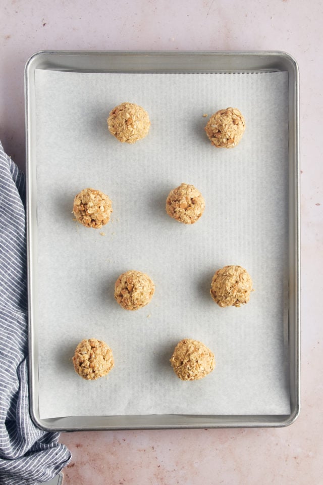 Overhead view of dough balls on parchment-lined baking sheet