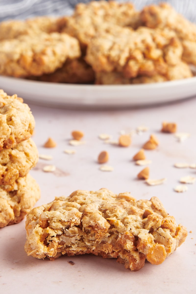 Bite taken out of oatmeal butterscotch cookie, with additional cookies in background