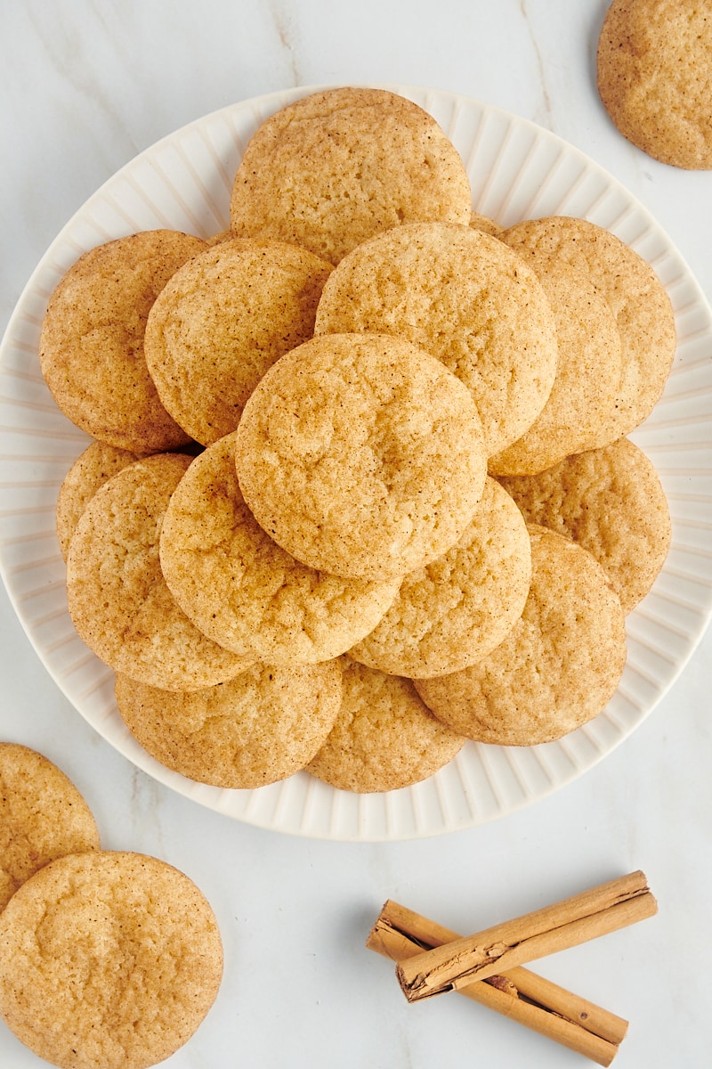 Overhead view of a pile of snickerdoodles on white plate.