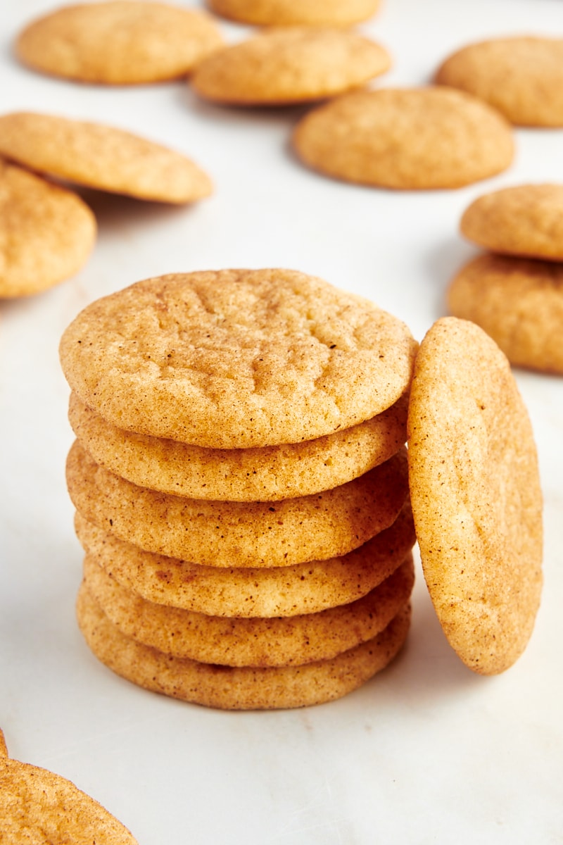 Stack of snickerdoodle cookies with one cookie leaning next to stack.