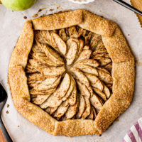 overhead view of apple galette on parchment paper on a wooden board