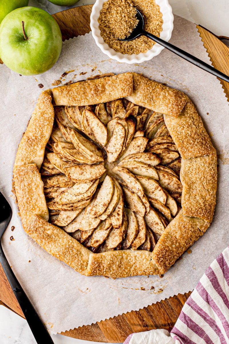 overhead view of apple galette on parchment paper on a wooden board