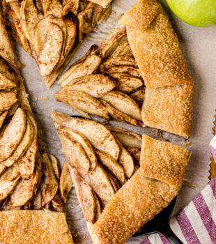 overhead view of a partially sliced apple galette on parchment paper