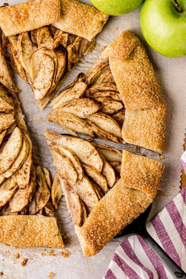 overhead view of a partially sliced apple galette on parchment paper
