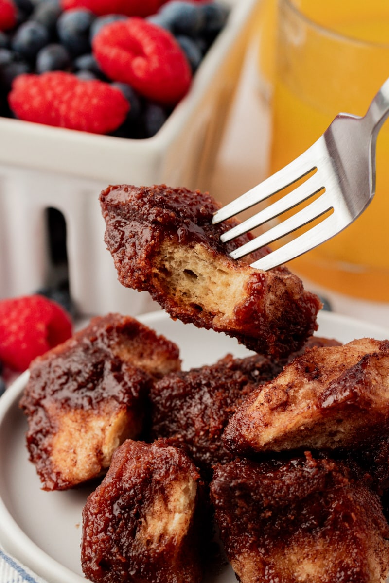 Fork holding piece of chocolate monkey bread over plate