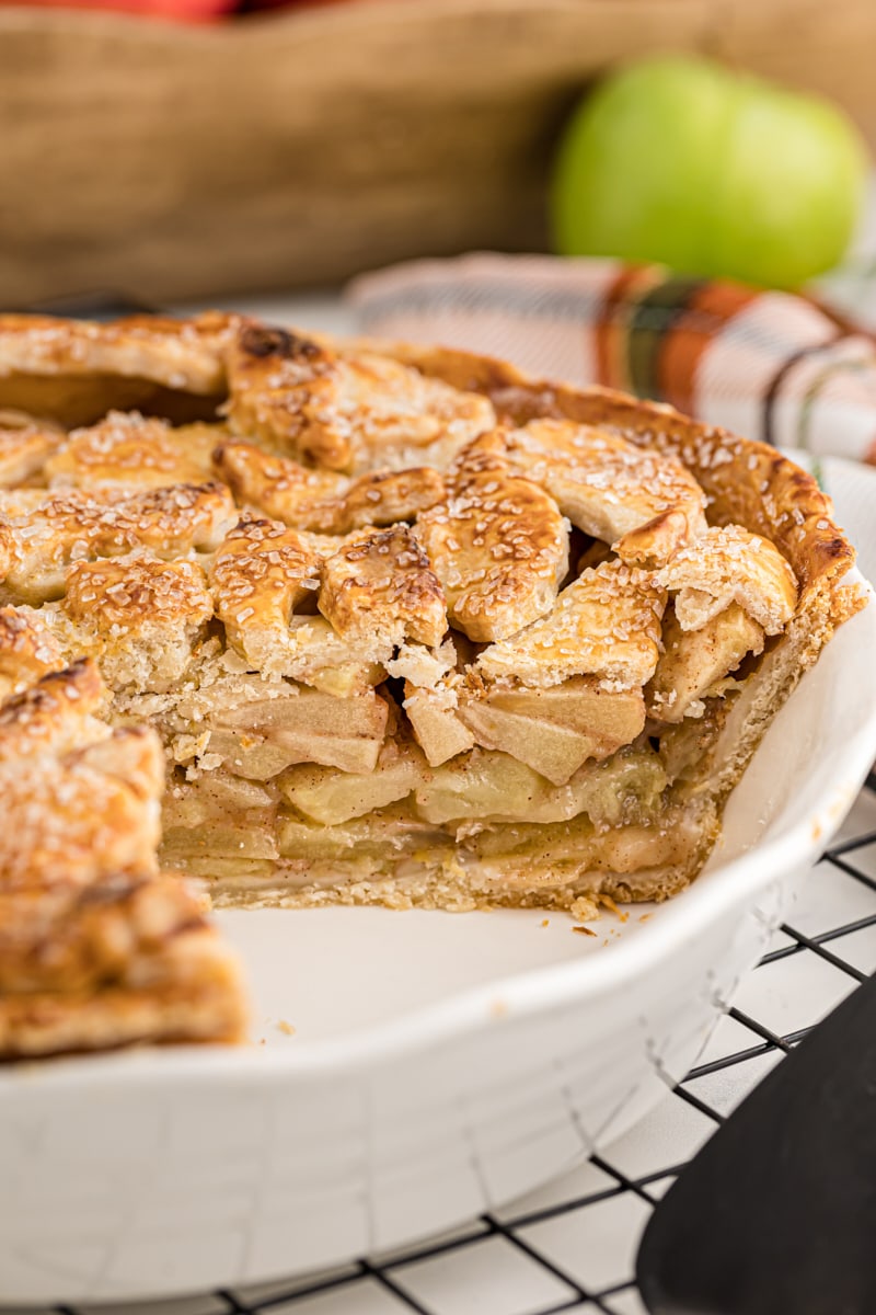 Apple pie in dish with pieces removed to show filling