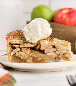 Side view of apple pie slice on plate with ice cream